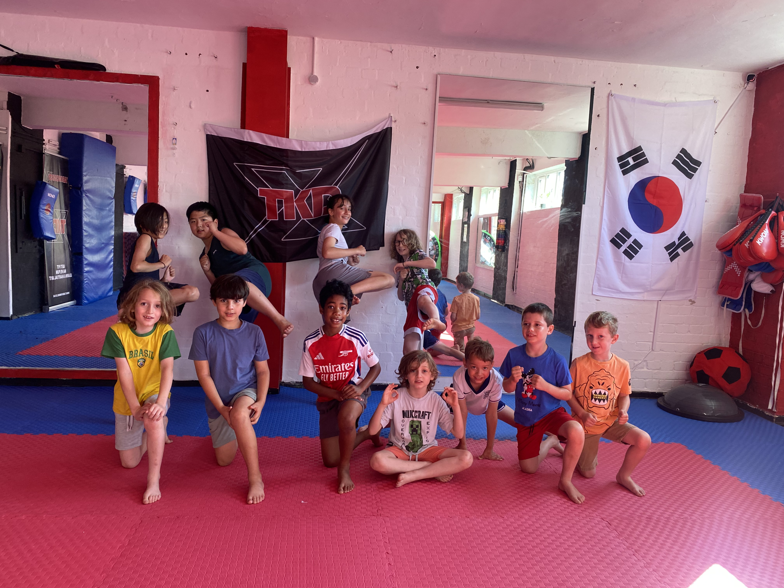 Children enjoying martial arts activities at a Taekwondo X holiday camp.